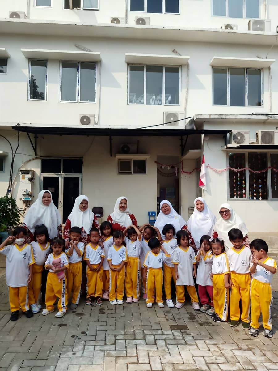 Foto bersama guru dan anak di halaman sekolah